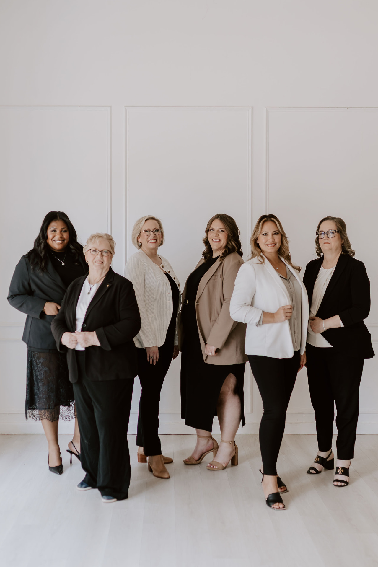 Six team members lined up in a bright white studio