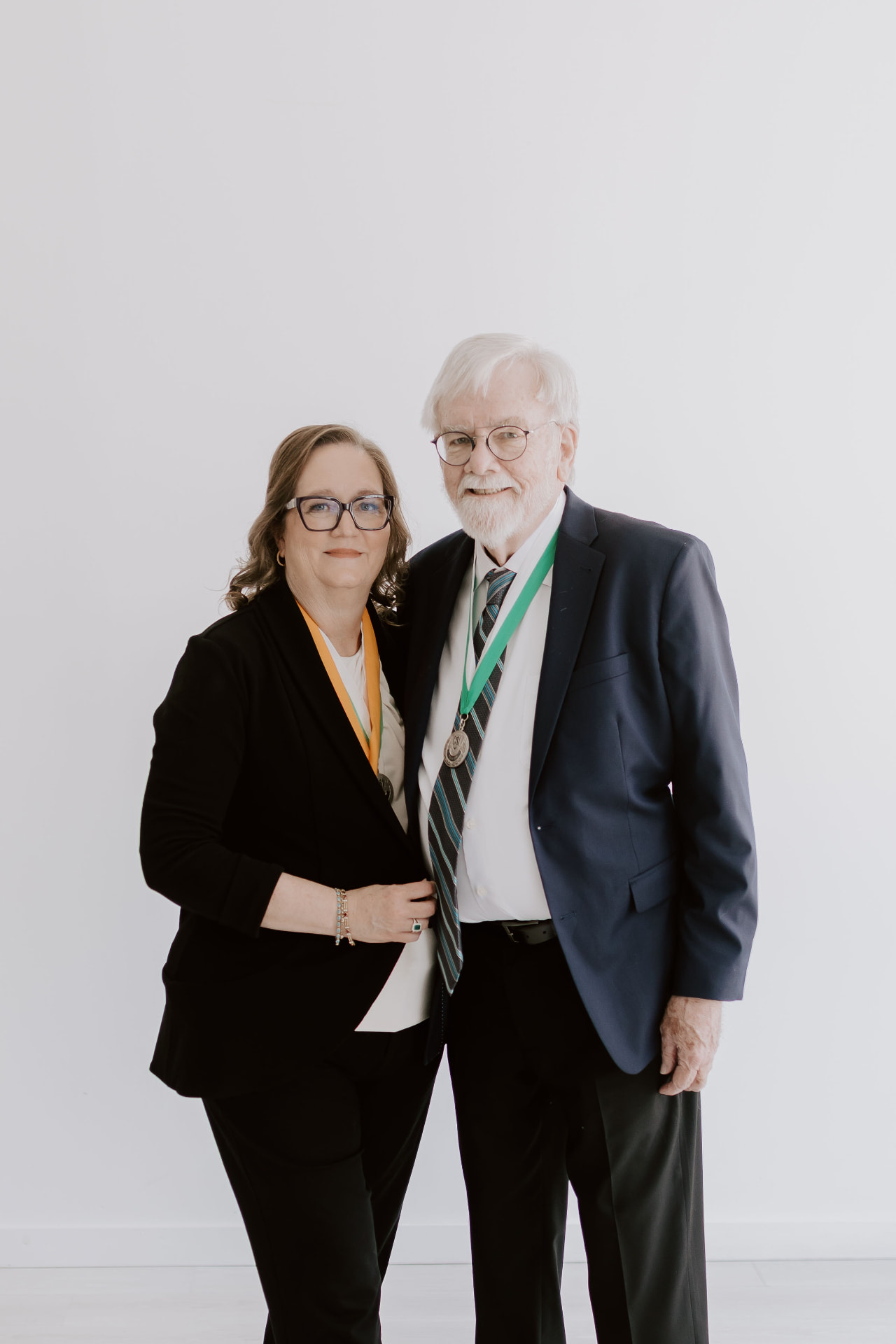 Holly and J. Peter Jordan wearing their CSI medals