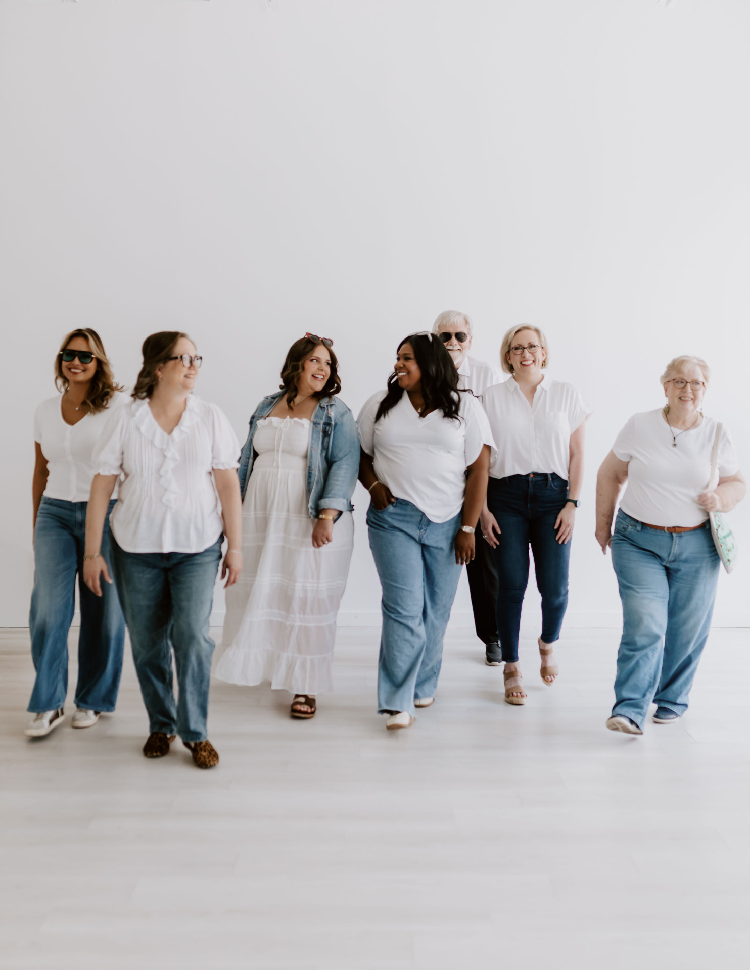 The team walking together in white shirts and denim